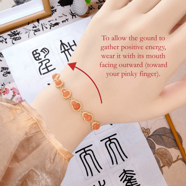 RUYI Jewelry wearing guide for Fire Element Nanhong (south red) Agate hulu bracelet. Shows the correct orientation: the hulu (gourd) opening should face the little finger, traditionally believed to direct positive energy.